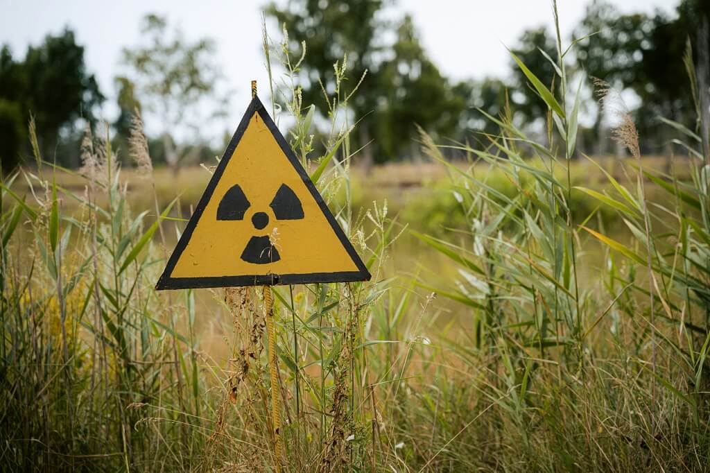 Schild warnt vor radioaktiven Stoffen auf der Wiese